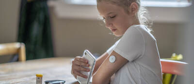 Young person testing their blood sugar with their mobile phone.