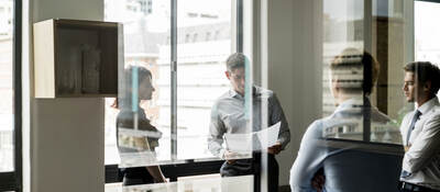 Business colleagues collaborating in a glass walled office