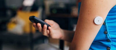 Person testing their blood sugar with wireless medical device