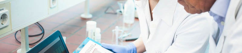 Two lab technicians looking at data on a computer