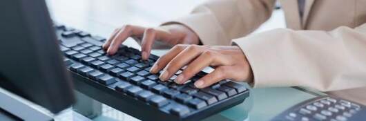 Hands typing on a keyboard.