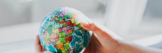 Hands holding a small globe