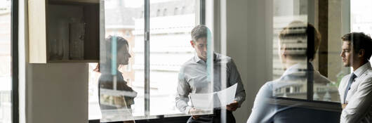 Business colleagues collaborating in a glass walled office