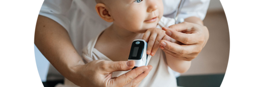 Doctor helping a baby use an oximeter