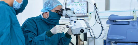 Two ophthalmologists performing operation on a patient's eyes