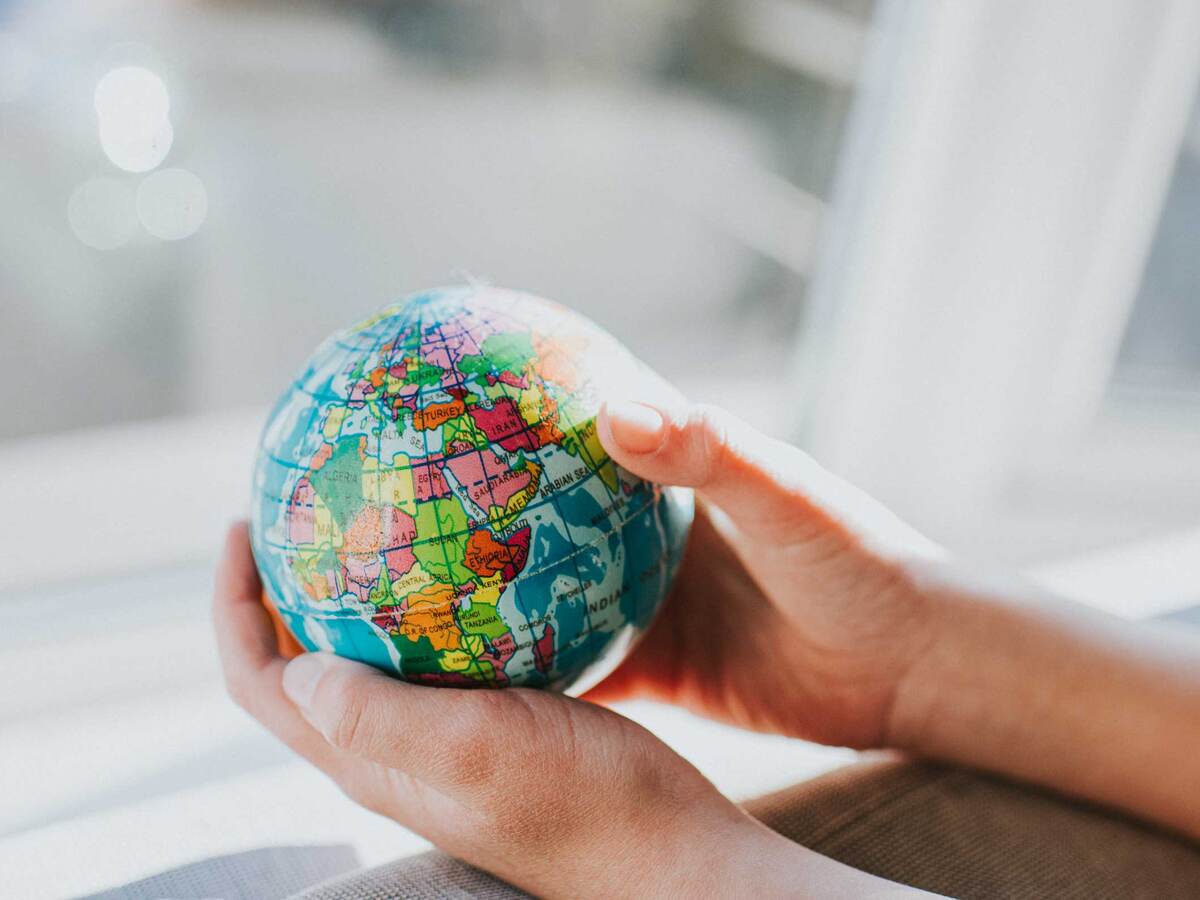 Hands holding a small globe