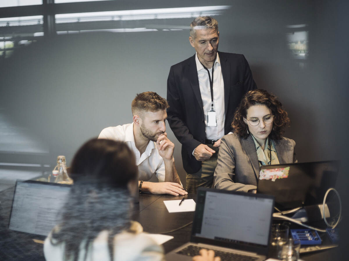 Colleagues collaborating in front of a laptop