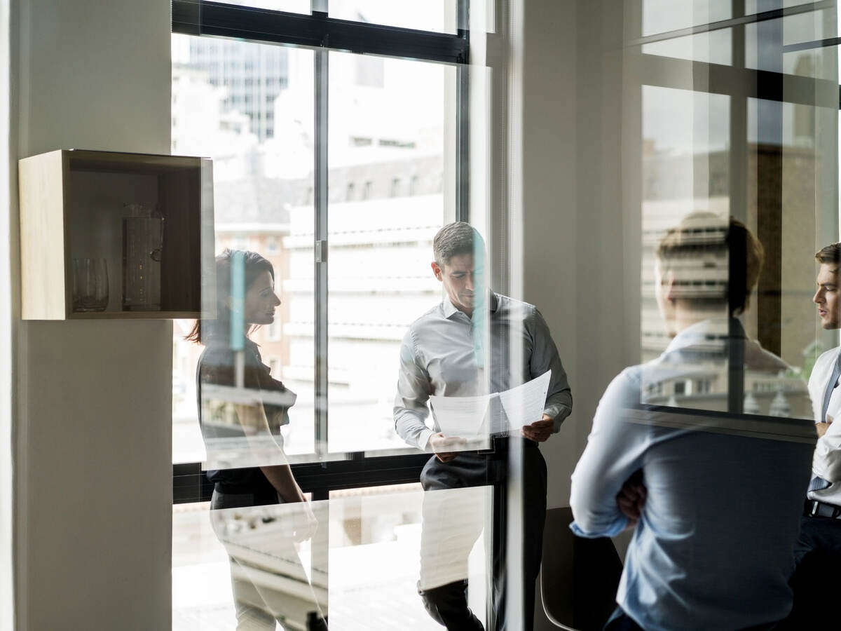 Business colleagues collaborating in a glass walled office