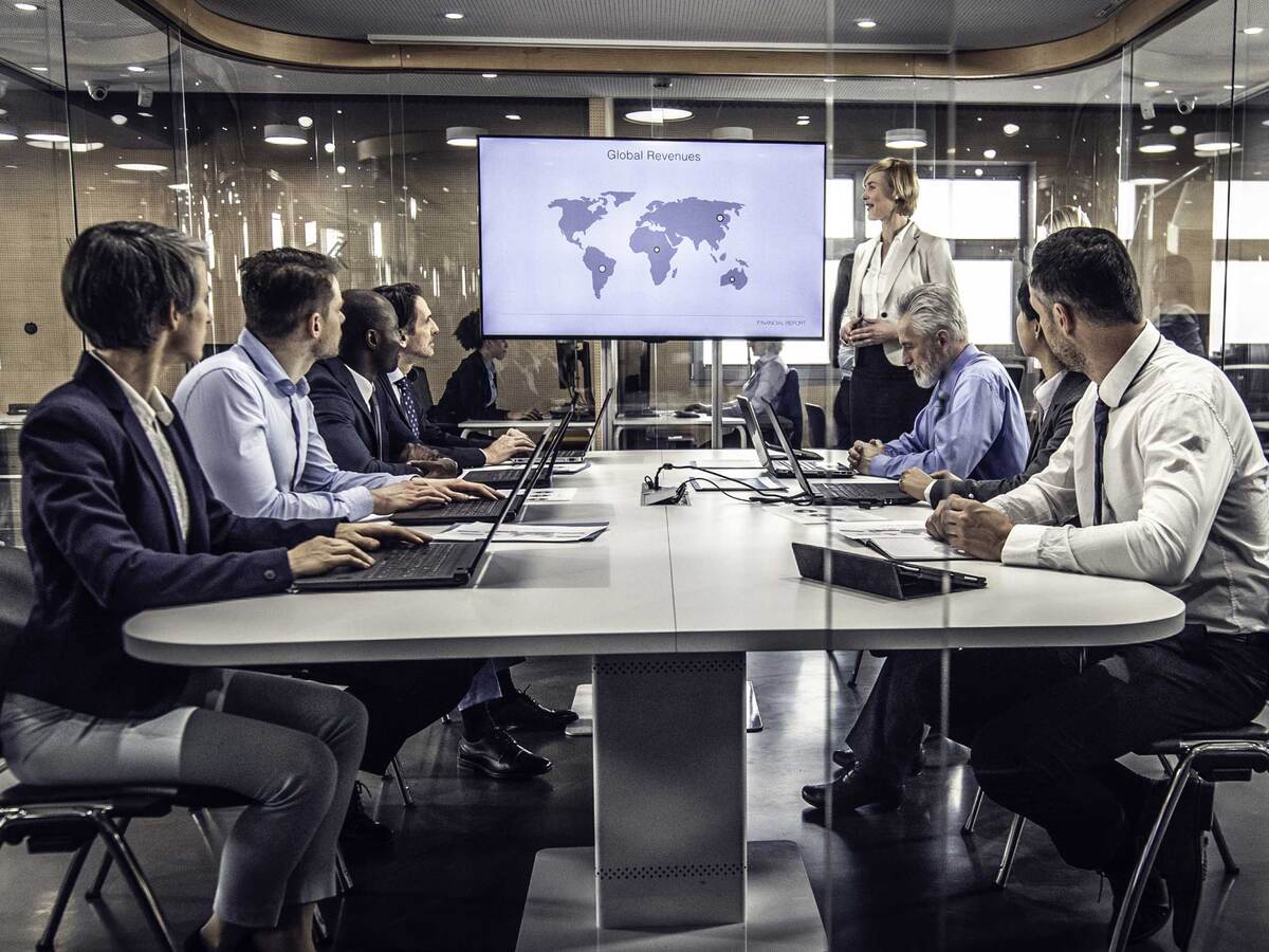 Group of business professionals having a meeting while looking at a map of the world