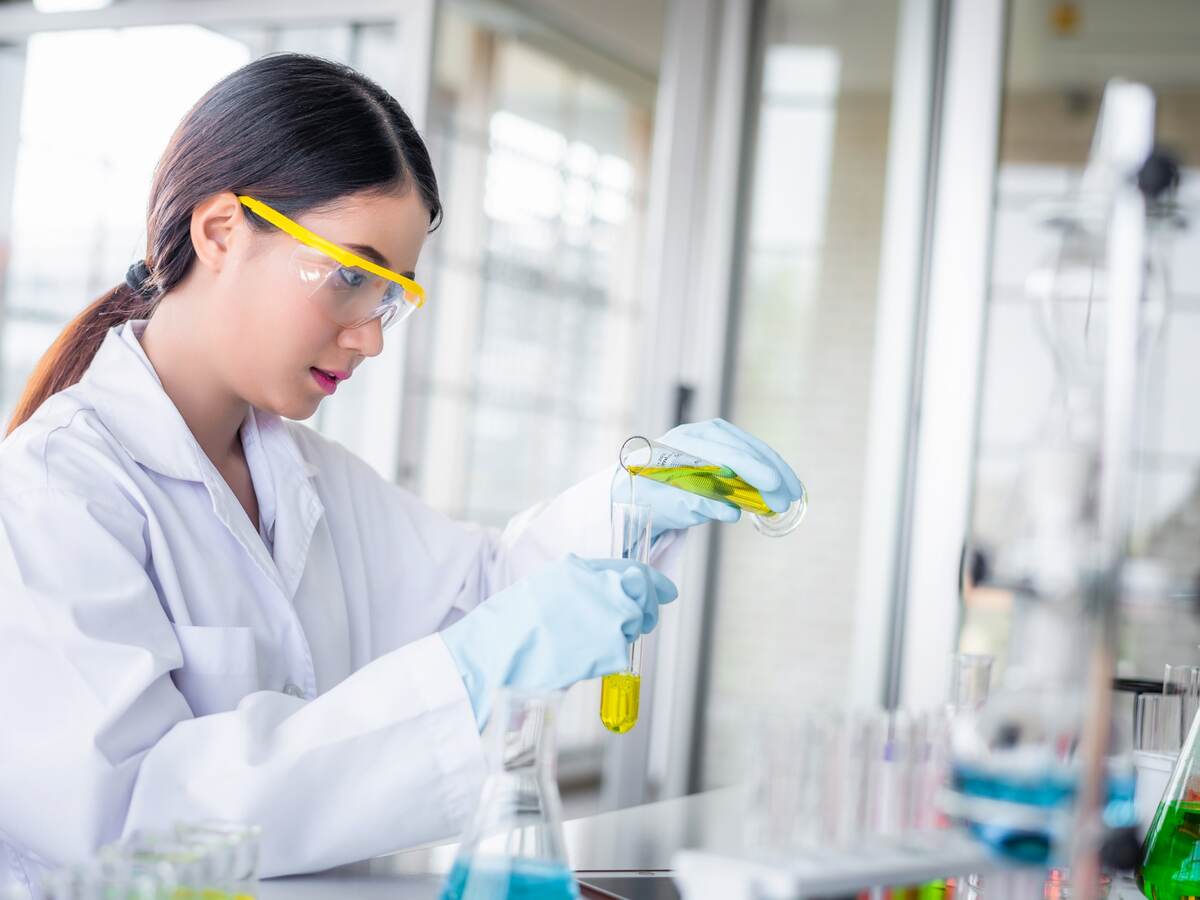 Scientist woman lab technical service observe liquid sample with lab glassware and test tubes in chemical laboratory