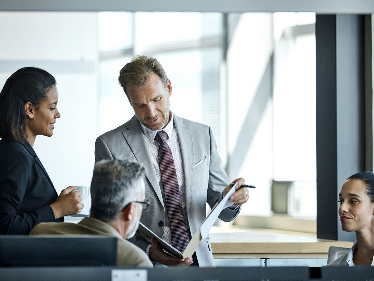 Business professional opening a portfolio to discuss it with colleagues