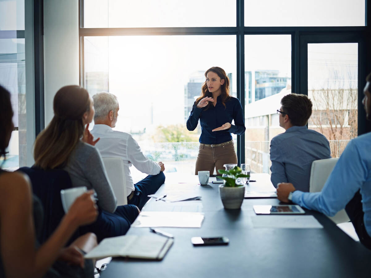 Person standing in front of a conference table to lead a meeting