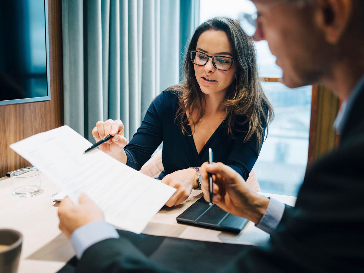 Two business professionals discussing regulations during a meeting