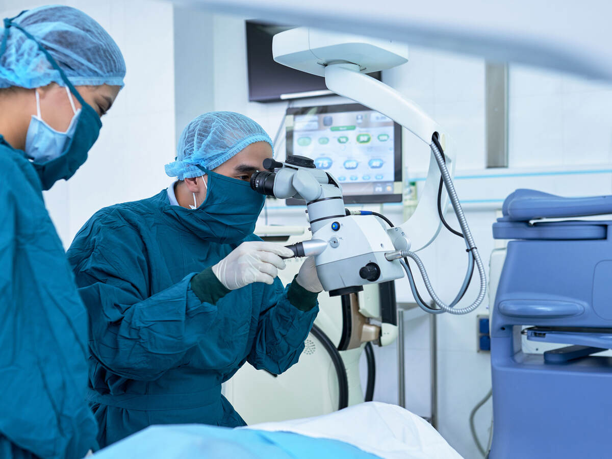 Two ophthalmologists performing operation on a patient's eyes